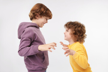 Cute little brothers having fun on white background