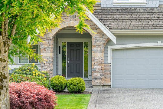 Entrance of grey painted luxury house in spring with stair steps and nice landscape in Vancouver, Canada, North America. Day time on April 2025.
