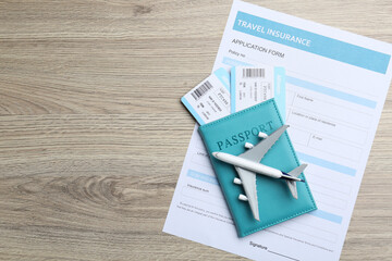 Medical tourism. Travel insurance application form, passport with tickets and airplane model on...
