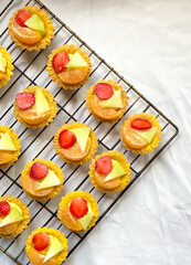 Mini Strawberry, pineapple, and orange Shortcake Tartlets with vanilla custard isolated on white cloth