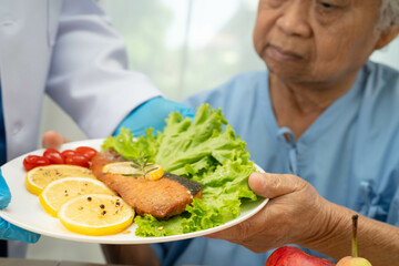 Asian Nutritionist holding healthy food for patient in hospital, nutrition and vitamin.