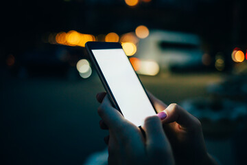 A person is holding a cell phone in their hand, looking at the screen