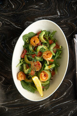 Portion of gourmet salad with fresh vegetables and shrimp