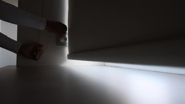 Womans hands lifting curtains roller blinds on the window in a chain, opening curtains in good day
