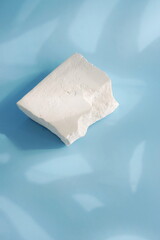 White stone pedestal, product presentation podium, template, abstract blue background with sunlight shadow. Top view.Minimalist concept,  display product, showcase for cosmetic products . Copy space