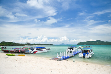The sea on the island has beautiful clouds in the sky.