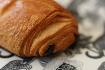 fresh pain au chocolat on white plate with tigers. top view
