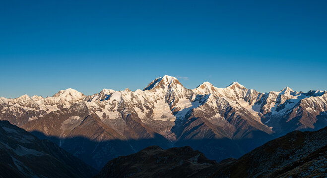 Majestic snow-capped mountains reaching towards the clear blue sky at daytime