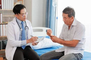 Obraz premium Elderly man seeks medical advice for wrist pain after strenuous work, consulting a specialist to discuss symptoms and possible treatment.