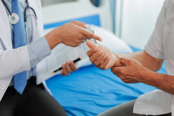 Elderly man seeks medical advice for wrist pain after strenuous work, consulting a specialist to discuss symptoms and possible treatment.