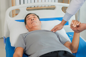 An elderly patient undergoes leg physiotherapy on a treatment bed while being carefully assisted...