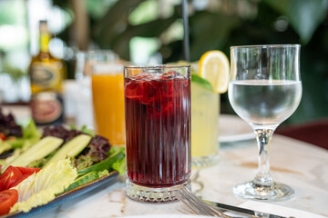 Close up view of a glass of fresh iced sour cherry juice served on a restaurant table.