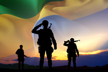 Silhouettes of a soldiers against the sunset with Gabon flag. National Holidays concept