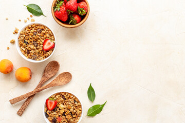Two bowls of cereal granola with strawberry and honey for breakfast, top view