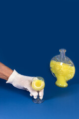 Hand in crocheted glove holding yellow liqueur with sun-shaped bottle