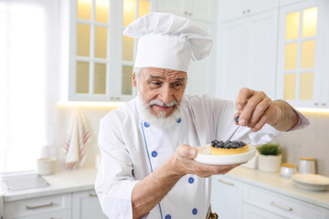 Elderly pastry chef making dessert in kitchen
