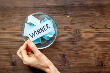 Plakat Hand is picking a winner ticket from glass jar, top view. Luck and lottery concept.