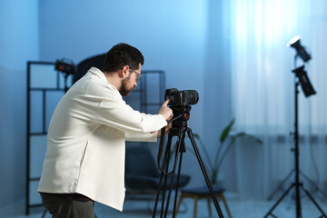 Man with professional video camera in studio, space for text