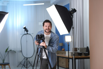 Happy man with professional video camera in studio