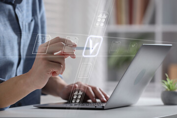 Man approving documents on virtual screen above laptop at table, closeup
