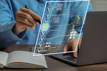 Man approving documents on virtual screen above laptop at table, closeup