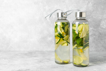 Cucumber water with lemon, lime and mint on a wooden table. Water infused with sliced...