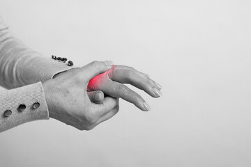 Arthritis. Woman suffering from pain in hand, closeup. Black and white toning with red color accent