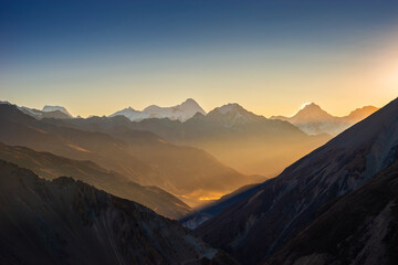 Himalaya mountains at sunrise. Himlung and Manaslu summits behind Pisang peak illuminated by first rays of the sun. View from the trekking route to Tilicho lake.