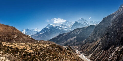 Thorung Khola gorge in autumn. The trekking route to Thorong La against snowy and high Gangapurna and Annapurna III peaks. Himalaya mountains, Nepal.