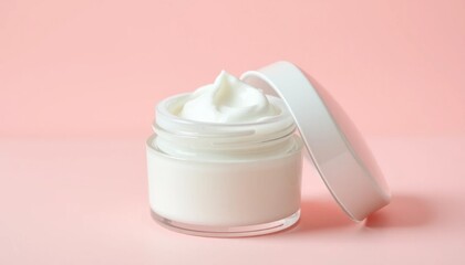 Hydrating facial cream in transparent jar offers nourishing skincare on pastel pink background