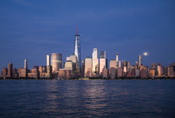 Obraz premium new york city skyline view during blue hour just after sunset (dusk nightfall night time photography from jersey city waterfront) hudson river downtown skyscrapers tall commercial buildings reflecting
