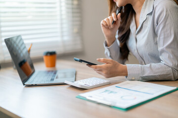 Female professional reviewing financial data on digital devices during workplace analysis