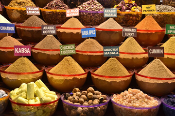 An assortment of spices with names on the shelves of a Dubai bazaar

