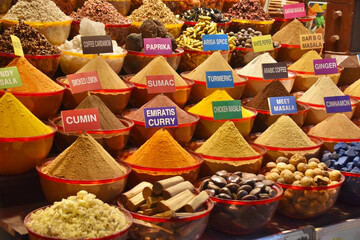 An assortment of spices with names on the shelves of a Dubai bazaar
