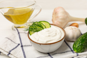 Cucumber sour cream tzatziki sauce on a wooden table.Tartar sauce. Traditional delicious appetizer. yogurt sauce. Tzatziki with ingredients cucumber, garlic,dill,lemon,mint. salad dressing.Copy space