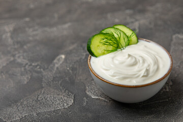 Cucumber sour cream tzatziki sauce on a wooden table.Tartar sauce. Traditional delicious appetizer. yogurt sauce. Tzatziki with ingredients cucumber, garlic,dill,lemon,mint. salad dressing.Copy space