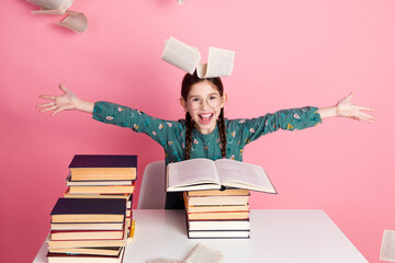 Cheerful young girl enjoying book and learning with an enthusiastic expression in a colorful and lively setting