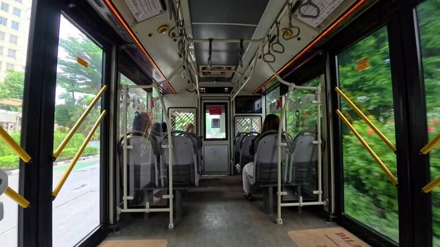 Jakarta - April 3, 2025: Transjakarta bus is empty of passengers. Several passengers are seen filling the seats inside the bus.