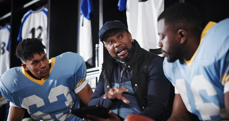 Man, American football player and coach with team in locker room, tablet and advice for...