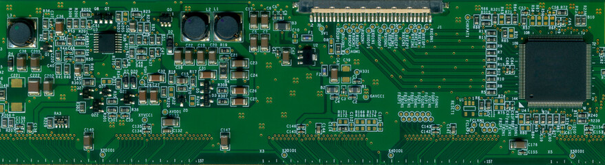 green printed circuit board with many electronic components and parts