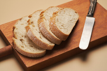Freshly Sliced Bread on a Wooden Cutting Board With a Knife Nearby