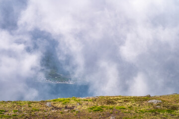 A breathtaking and serene view of mist covered mountains, with vibrant green patches and soft, fluffy clouds gently rolling over a tranquil and idyllic landscape, Carlingford, Ireland
