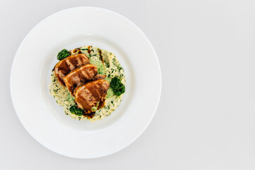 Grilled chicken served on creamy spinach puree with vibrant green sauce