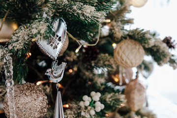 Decorative ornaments on a festive Christmas tree adorned with lights and holiday cheer