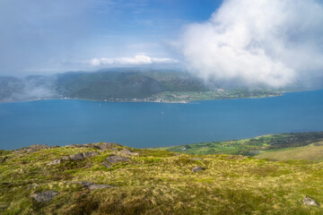 A stunning view of a tranquil and serene blue sea nestled beautifully between lush green hills and softly rolling clouds, showcasing the breathtaking beauty of nature, Carlingford, Ireland