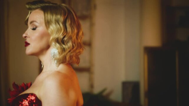 Blurred silhouette Blonde hair blue eyes sexy woman posing walking looking at camera in dark night ball room old style. Retro lady girl in luxury red shiny long dress, holiday concept festive party 