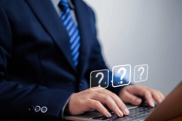Question mark, Businessman showing question mark icon in front of laptop, Technology question concept, FAQ, Wondering questioning and problem-solving, Q and A, ask	