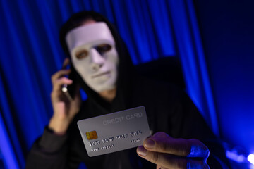 White criminal anonymous mask calling to credit card owner to threaten ransom with privacy...