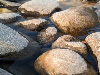 Stones in shallow waters with reflection detail