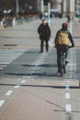 Cyclist navigating along a bustling urban pathway on a sunny afternoon in the heart of the city